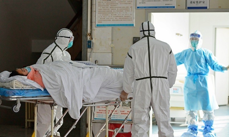 Các bác sĩ chuyển bệnh nhân nhiễm nCoV vào khu vực cách ly ở bệnh viện thành phố Phụ Dương, tỉnh An Huy hôm 1/2. Ảnh: AP.
