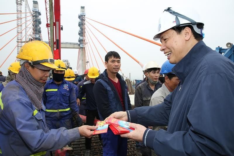 Chủ tịch UBND tỉnh Quảng Ninh trò chuyện, chúc Tết công nhân thi công dự án cầu Bạch Đằng ngày 30 Tết. Ảnh: Đỗ Phương
