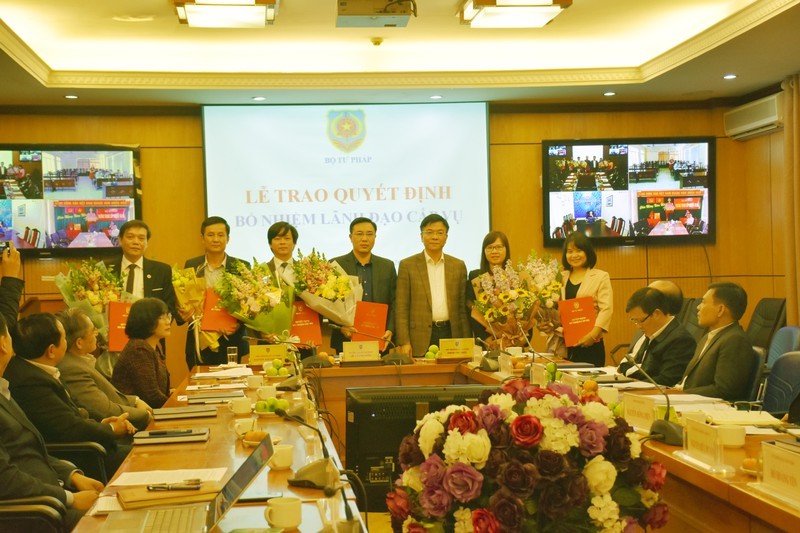 Bộ trưởng Bộ Tư pháp Lê Thành Long trao quyết định và tặng hoa chúc mừng các cán bộ được bổ nhiệm.