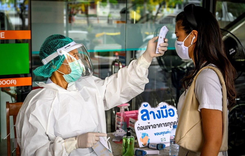 Nhân viên y tế kiểm tra thân nhiệt phòng lây nhiễm COVID-19 tại Bangkok,Thái Lan. (Ảnh: AFP/TTXVN).
