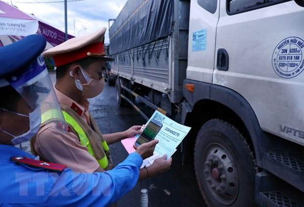 Lực lượng chức năng quét mã QR code trên điện thoại thông minh đối với phương tiện giao thông vào Hà Nội qua chốt kiểm soát dịch huyện Chương Mỹ. (Ảnh: Phạm Kiên/TTXVN).