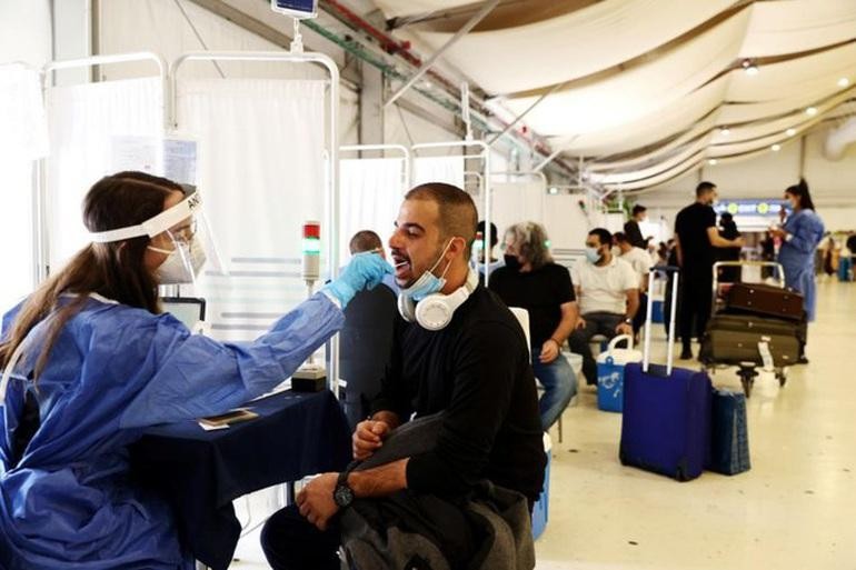 Nhân viên y tế lấy mẫu xét nghiệm tại sân bay ở Israel (Ảnh: Reuters).