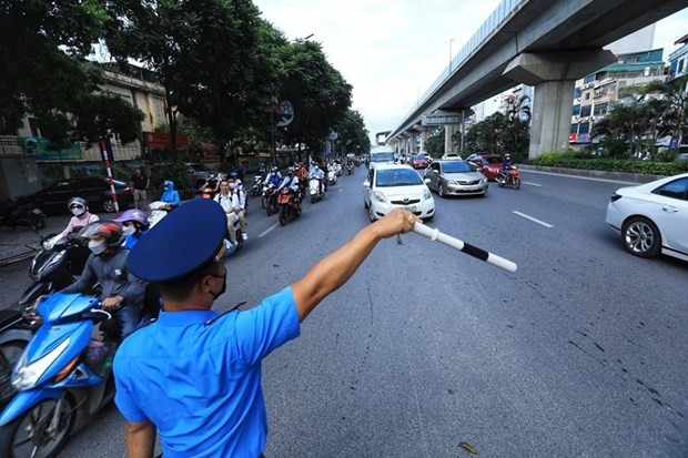 Lực lượng Thanh tra giao thông hướng dẫn người dân đi theo làn đường quy định. (Ảnh: Tuấn Anh/TTXVN)