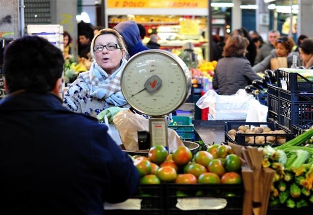 Người dân mua thực phẩm tại một khu chợ ở Rome (Italy). (Ảnh: AFP/TTXVN).