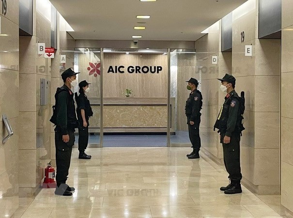 Lực lượng Cảnh sát điều tra làm nhiệm bảo vệ trong quá trình khám xét tại trụ sở Công ty AIC, 69 phố Tuệ Tĩnh, ngày 29/4/2022. (Ảnh: Phạm Kiên/TTXVN).
