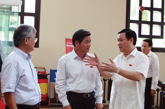Bộ trưởng Bộ Kế hoạch và Đầu tư Bùi Quang Vinh (đứng giữa) trao đổi cùng đại biểu Quốc hội về một số vấn đề liên quan tới Dự thảo Luật 