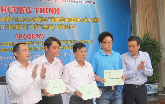 Ông Nguyễn Quang Phi - Phó Tổng Giám đốc Bảo hiểm Bảo Việt trao tiền bồi thường cho các doanh nghiệp tại Đồng Nai