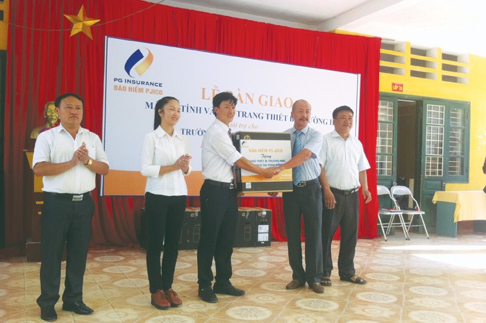 Ông Bùi Hoài Giang, Phó tổng giám đốc Tổng CTCP Bảo hiểm Petrolimex (PJICO) trao tặng tài trợ cho ông Nguyễn Trung Kiên, Hiệu trưởng Trường THCS Thị trấn Đồng Văn