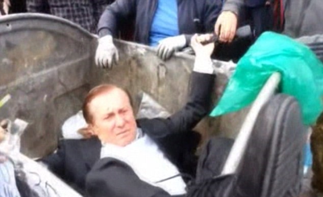 Nghị sĩ Vitaly Zhuravsky bị đám đông ném vào thùng rác (Nguồn: DM)
