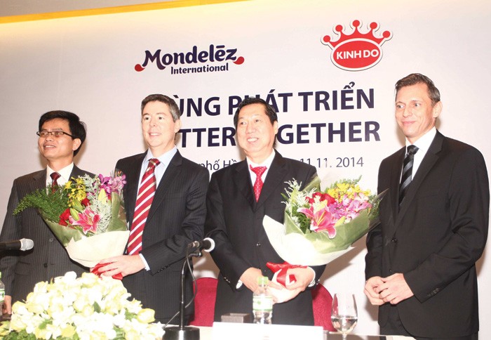 Ông Trần Kim Thành, Chủ tịch HĐQT Kinh Đô (thứ hai từ phải sang) và ông Tim Cofer, Phó chủ tịch cấp cao Tập đoàn Mondelez (thứ hai từ trái sang) tại Lễ ký Thỏa thuận mua bán cổ phần của BKD - Ảnh: Lê Toàn