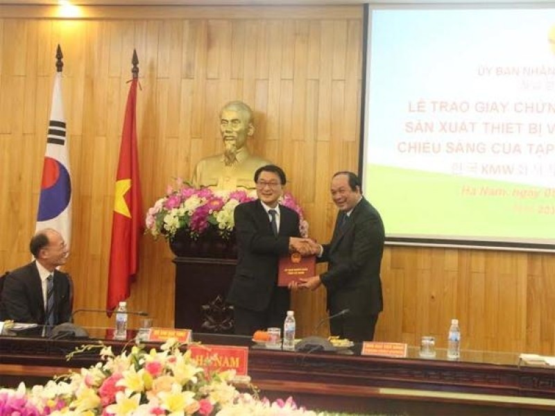 Bí thư Tỉnh ủy Hà Nam Mai Tiến Dũng (bên phải) trao Giấy chứng nhận đầu tư cho ông ông Kim Duk Yong, Chủ tịch Tập đoàn KMW (Hàn Quốc)