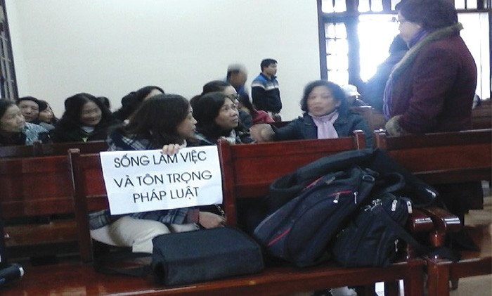 Cổ đông mang biểu ngữ trong một phiên tòa ở Hải Phòng năm 2014