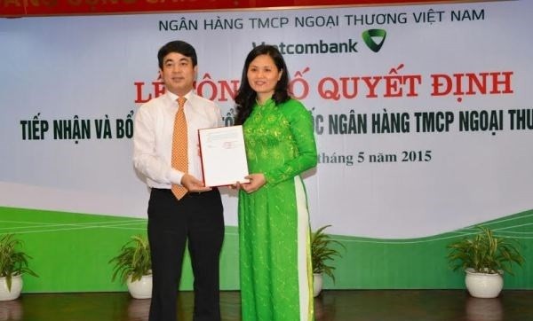 Chủ tịch Hội đồng quản trị Nghiêm Xuân Thành trao quyết định tiếp nhận và bổ nhiệm cho bà Đinh Thị Thái. Nguồn: Vietcombank