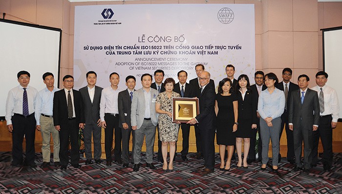 Chủ tịch VSD bà Phương Hoàng Lan Hương trao quà lưu niệm cho ông Alain Raes, Tổng giám đốc khu vực châu Á - Thái Bình Dương và khu vực châu Âu - Trung Đông - 
châu Phi của SWIFT, với sự chứng kiến của lãnh đạo UBCK và các thành viên của VSD 