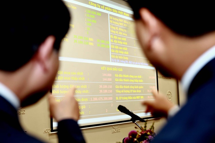 Các nhà đầu tư đang xem kết quả đấu giá cổ phiếu Vinamilk của SCIC ngày 12/12 - Ảnh: Lê Toàn