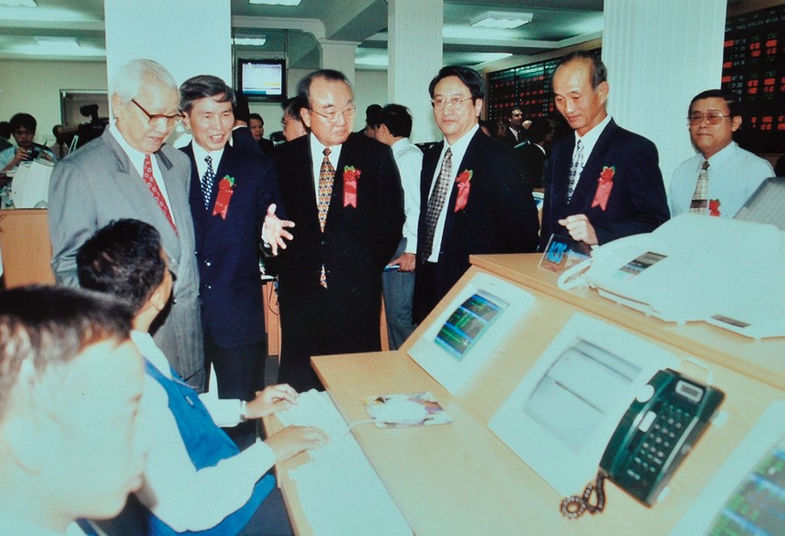 Chủ tịch Ủy ban Chứng khoán Nhà nước Nguyễn Đức Quang dẫn nguyên Thủ tướng Võ Văn Kiệt thăm sàn giao dịch trong ngày đầu tiên khai mở, 20 tháng 7 năm 2000