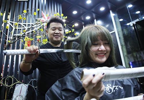 Kỷ lục gia Nguyễn Hoàng Hưng biểu diễn cắt tóc bằng hai thanh kiếm Nhật. Ảnh: Nguyễn Đông.