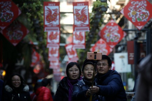Một gia đình khách Trung Quốc chụp ảnh trước con đường trang trí cho dịp Tết Âm lịch. Ảnh: Reuters.