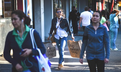 Người dân Mỹ đi dạo và mua sắm trên đường phố. Ảnh: Bloomberg