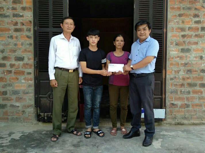 Nhà báo Hoàng Kim Thủy, Trưởng đại diện Văn phòng Báo Đầu tư khu vực miền Trung - Tây Nguyên trao món quà 30 triệu đồng của Báo Đầu tư cho em Trần Văn Nam.