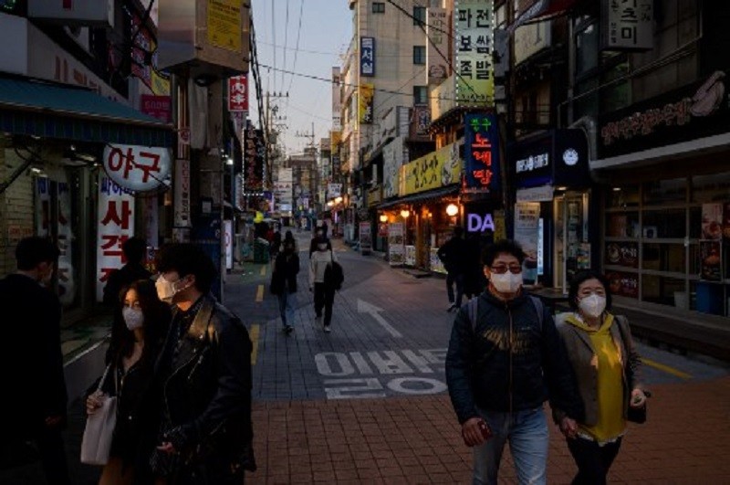 Người dân đi bộ trên đường phố Seoul hôm 24/3. Ảnh: AFP