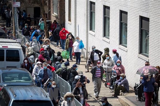 Người dân xếp hàng chờ nhận thực phẩm cứu trợ tại New York, Mỹ. (Ảnh: THX/TTXVN)