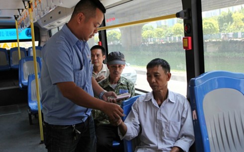 Phụ xe thu tiền vé hành khách trên tuyến buýt xã hội hóa số 44 (Mỹ Đình - Trần Khánh Dư)