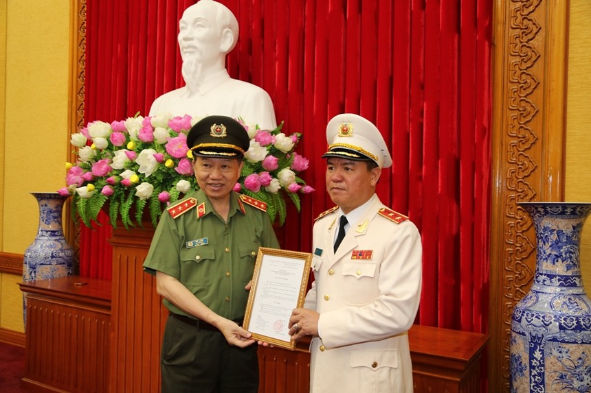 Bộ trưởng Tô Lâm trao quyết định cho Trung tướng Trần Văn Vệ. Ảnh MPS