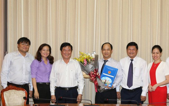 Ông Lê Đức Thanh (ôm hoa) trong buổi lễ trao quyết định giữ chức vụ Phó giám đốc Sở Tư pháp TP HCM mới.