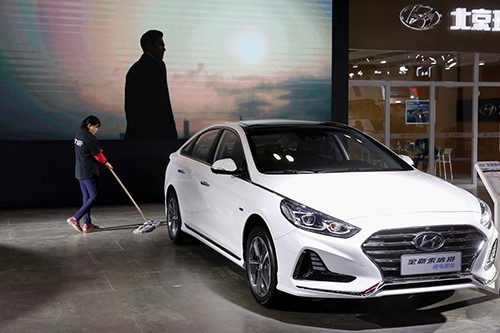 Một công nhân lau sàn cạnh chiếc Sonata Hybrid tại gian hàng của Hyundai Bắc Kinh ở triển lãm tiết kiệm năng lượng hôm 18/10, Bắc Kinh. Ảnh: Reuters/Thomas Peter