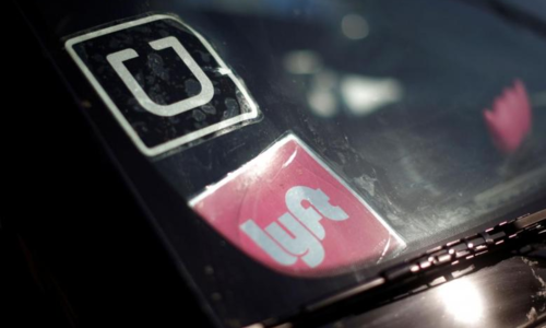 Logo của Uber và Lyft trên một xe hơi tại Mỹ. Ảnh: Reuters.