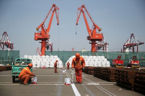 Công nhân đang sơn lại nền tại một cảng của Thanh Đảo, Sơn Đông, Trung Quốc. Ảnh: Reuters