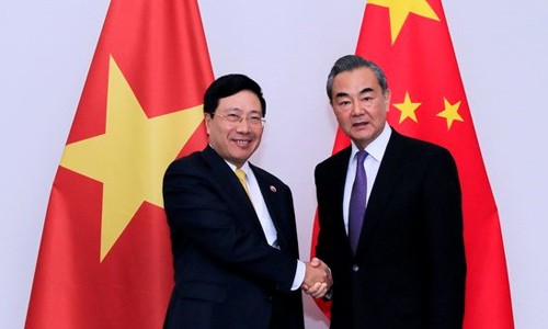 Ngoại trưởng Trung Quốc Vương Nghị, phải, và Phó thủ tướng Việt Nam Phạm Bình Minh trong cuộc gặp ngày 16/12 tại Lào. Ảnh: TTXVN.
