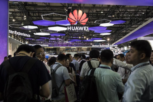 Khách tham quan trước gian hàng của Huawei tại Triển lãm Di động tại Thượng Hải. Ảnh: Bloomberg.