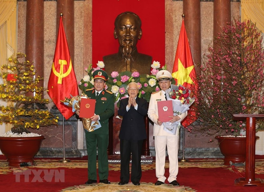 Tổng Bí thư, Chủ tịch nước Nguyễn Phú Trọng trao quyết định phong quân hàm Đại tướng và tặng hoa chúc mừng các đồng chí Tô Lâm, Lương Cường. Ảnh TTXVN.