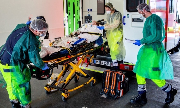Nhân viên y tế chuyển bệnh nhân Covid-19 từ Italy tới bệnh viện ở phía tây nước Đức hôm 28/3. Ảnh: AFP.