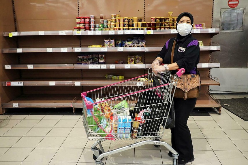 Một phụ nữ đeo khẩu trang mua đồ trong một siêu thị ở Kuala Lumpur. Ảnh: Reuters.