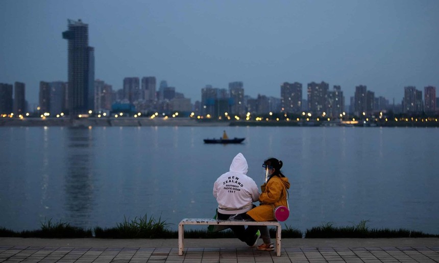 Một cặp đôi ngồi bên bờ sông ở Vũ Hán. Cuộc sống ở Vũ Hán đang dần trở lại bình thường sau đợt bùng phát dịch Covid-19. Ảnh: Xinhua.