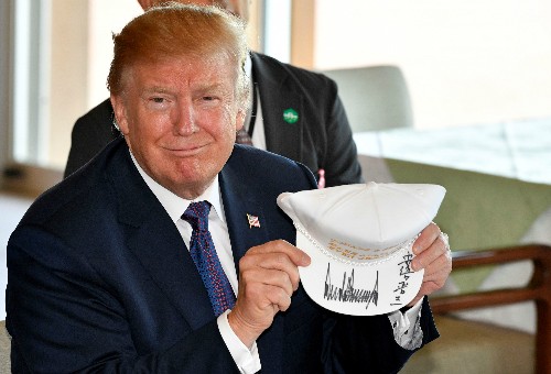 Tổng thống Mỹ Trump cầm chiếc mũ có chữ "Khiến liên minh ngày càng vĩ đại hơn" ở Nhật ngày 5/11. Ảnh: AA.