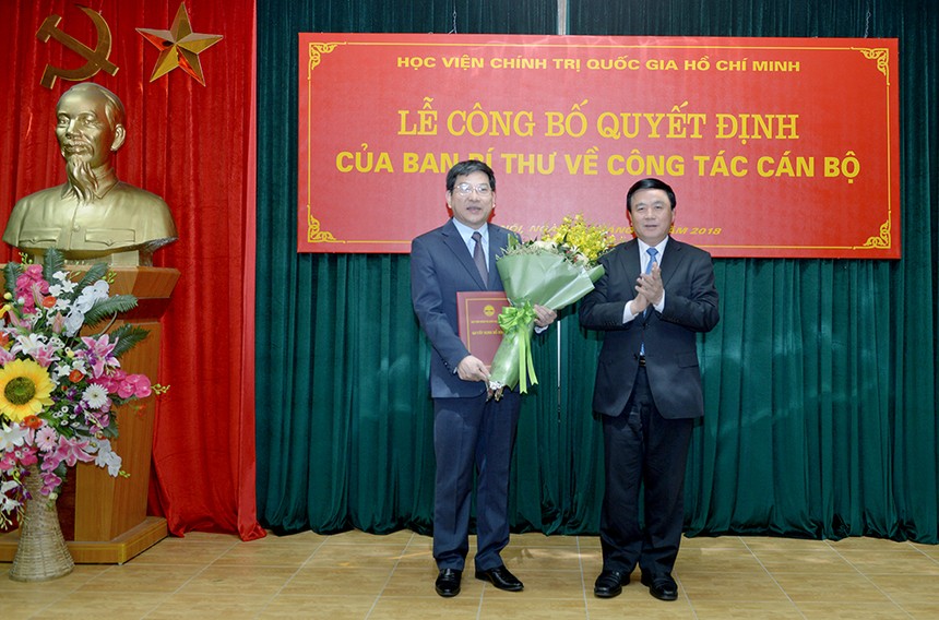 GS.TS. Nguyễn Xuân Thắng (phải) trao quyết định và tặng hoa chúc mừng đồng chí Nguyễn Duy Bắc