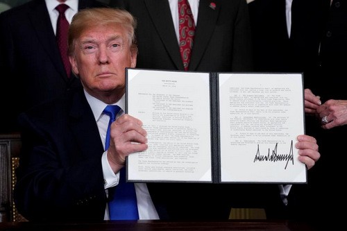 Tổng thống Donald Trump ký bản ghi nhớ áp thuế với Trung Quốc hôm 22/3. Ảnh: Reuters.