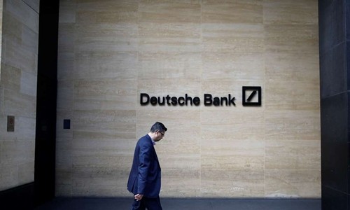 Một người đàn ông đi qua văn phòng của Deutsche Bank ở London. Ảnh: Bloomberg