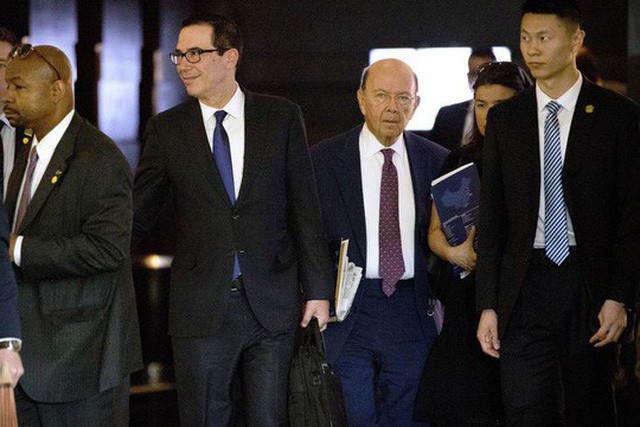 Bộ trưởng Tài chính Mỹ Steven Mnuchin (thứ 2 từ trái qua) và Bộ trưởng Thương mại Wilbur Ross (thứ 3) rời khỏi khách sạn tại thủ đô Bắc Kinh - Trung Quốc sau cuộc đàm phán hôm 4-5 Ảnh: AP