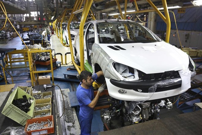 Một công nhân Iran đang lắp đặt xe hơi tại xưởng sản xuất ở thủ đô Tehran. Ảnh: AP.
