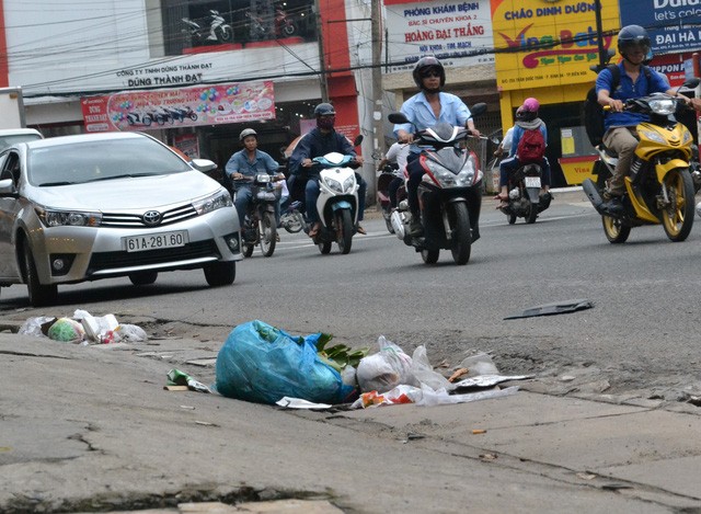 Rác thải sinh hoạt bị người dân vứt bỏ ngay trên miệng cống thu nước ở một tuyến phố tại TP Biên Hòa.