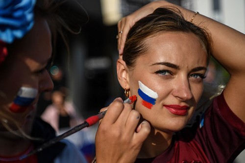 Một nữ cổ động viên Nga vẽ cờ lên mặt để cổ vũ đội nhà trong trận gặp Ai Cập hôm 19/6. Ảnh: AFP.