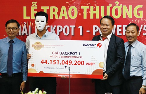 Khách hàng đeo mặt nạ che mặt khi nhận giải thưởng hơn 44 tỷ đồng. Ảnh: Xuân Ngọc.