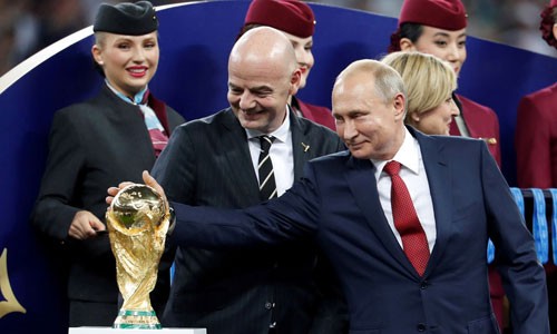Tổng thống Nga Putin (phải) chạm vào cúp vàng World Cup sau trận chung kết hôm qua. Ảnh: Reuters. 
