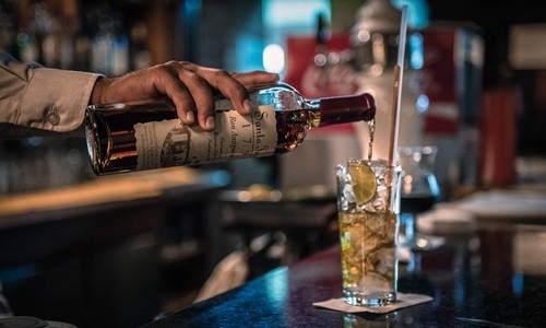 Một nhân viên pha chế đang làm cocktail với rượu rum tại Venezuela. Ảnh: Bloomberg.