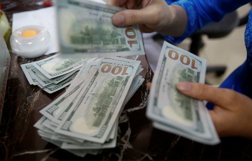 Một nhân viên ngân hàng đếm tiền USD tại Hà Nội. Ảnh: Reuters.
